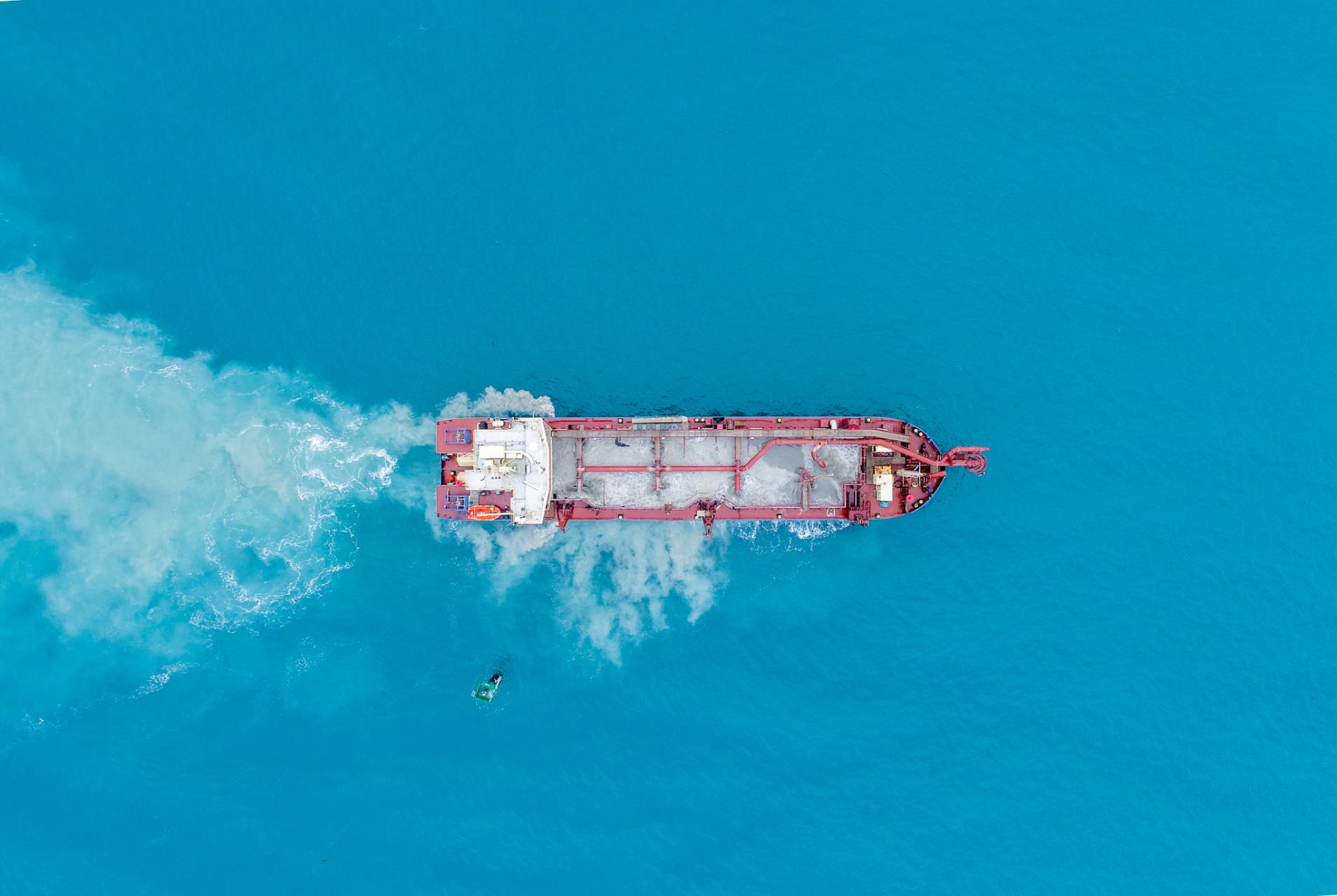 Overhead view of cargo ship travelling in ocean