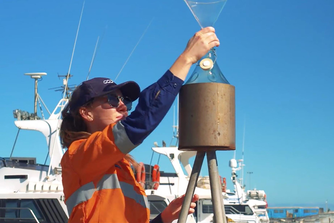 Upclose image of female staff member conducting experiment outdoors on marina