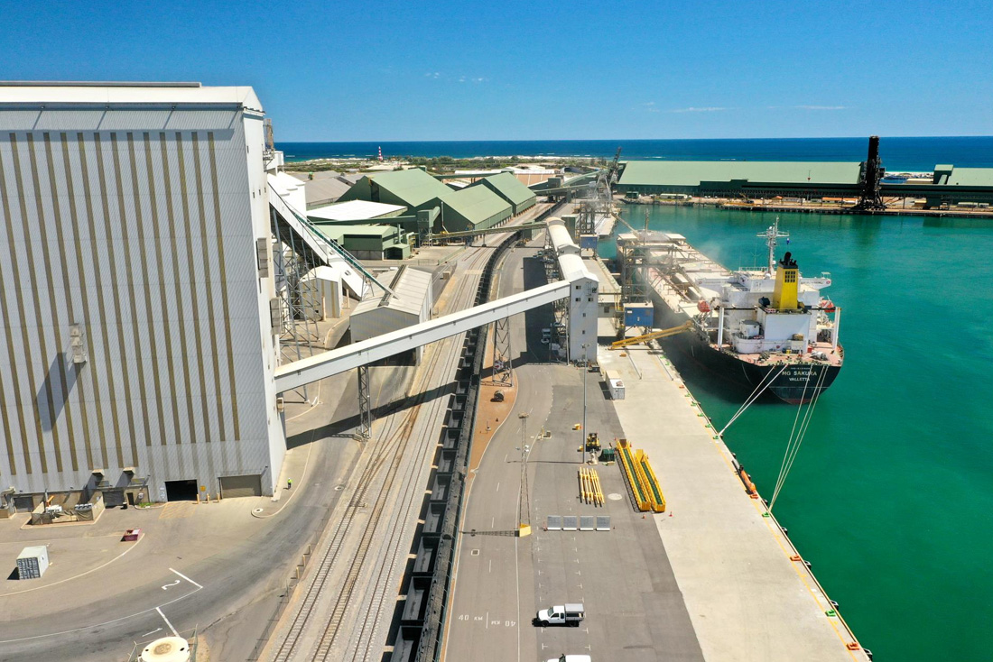 Cargo ship on the right at Berth 3 with buildings and bridges on the left