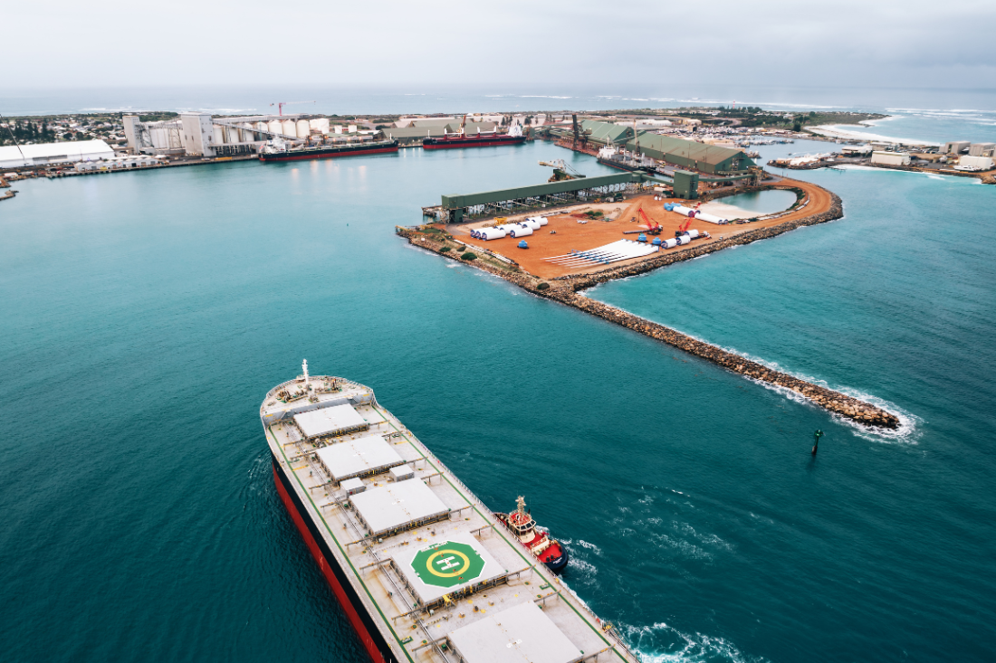 A bulk carrier is guided into port by 2 tugboats